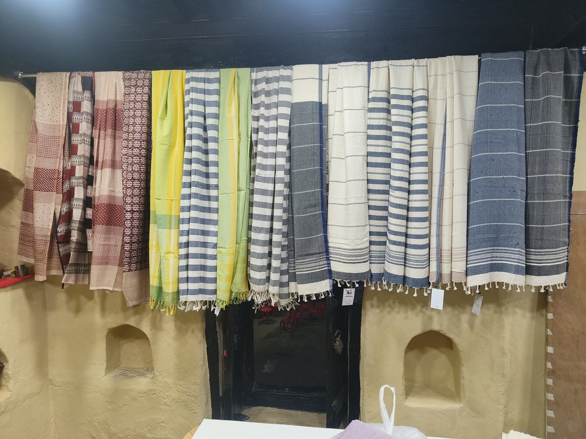 Handwoven cotton stoles in striped and patterned weaves hanging on display